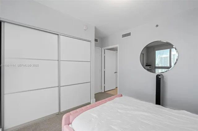 a bedroom with a bed and a mirror