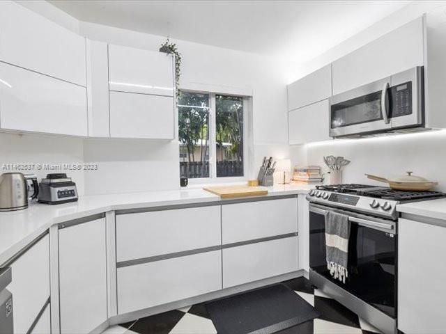 600 Surfside Boulevard Surfside, FL 33154 - Photo 23 of 31 a kitchen with granite countertop white cabinets stainless steel appliances and sink