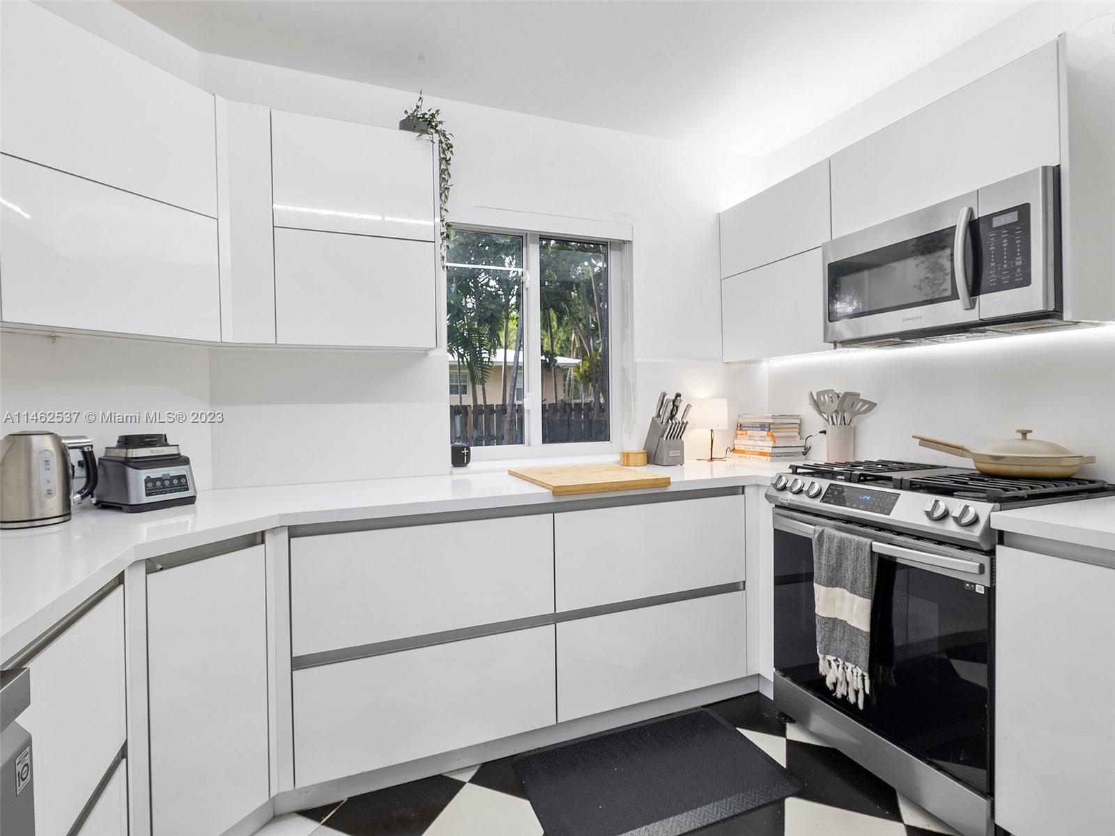 600 Surfside Boulevard Surfside, FL 33154 - Photo 28 of 31 a kitchen with granite countertop white cabinets stainless steel appliances and sink