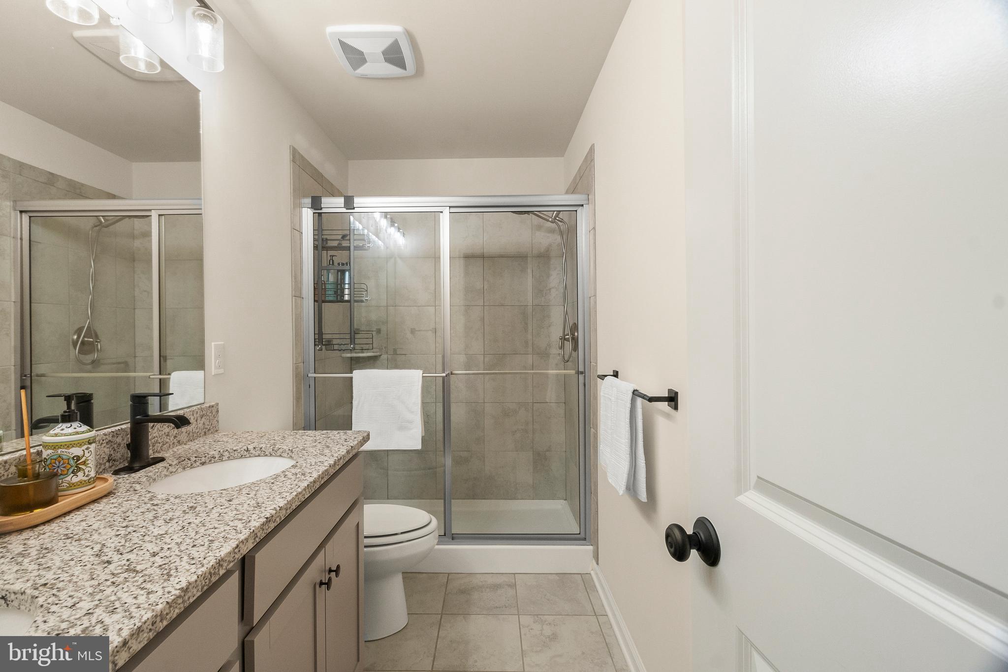 407 Sun Boulevard Bear, DE 19701 - Photo 51 of 69 a bathroom with a granite countertop sink a toilet and shower