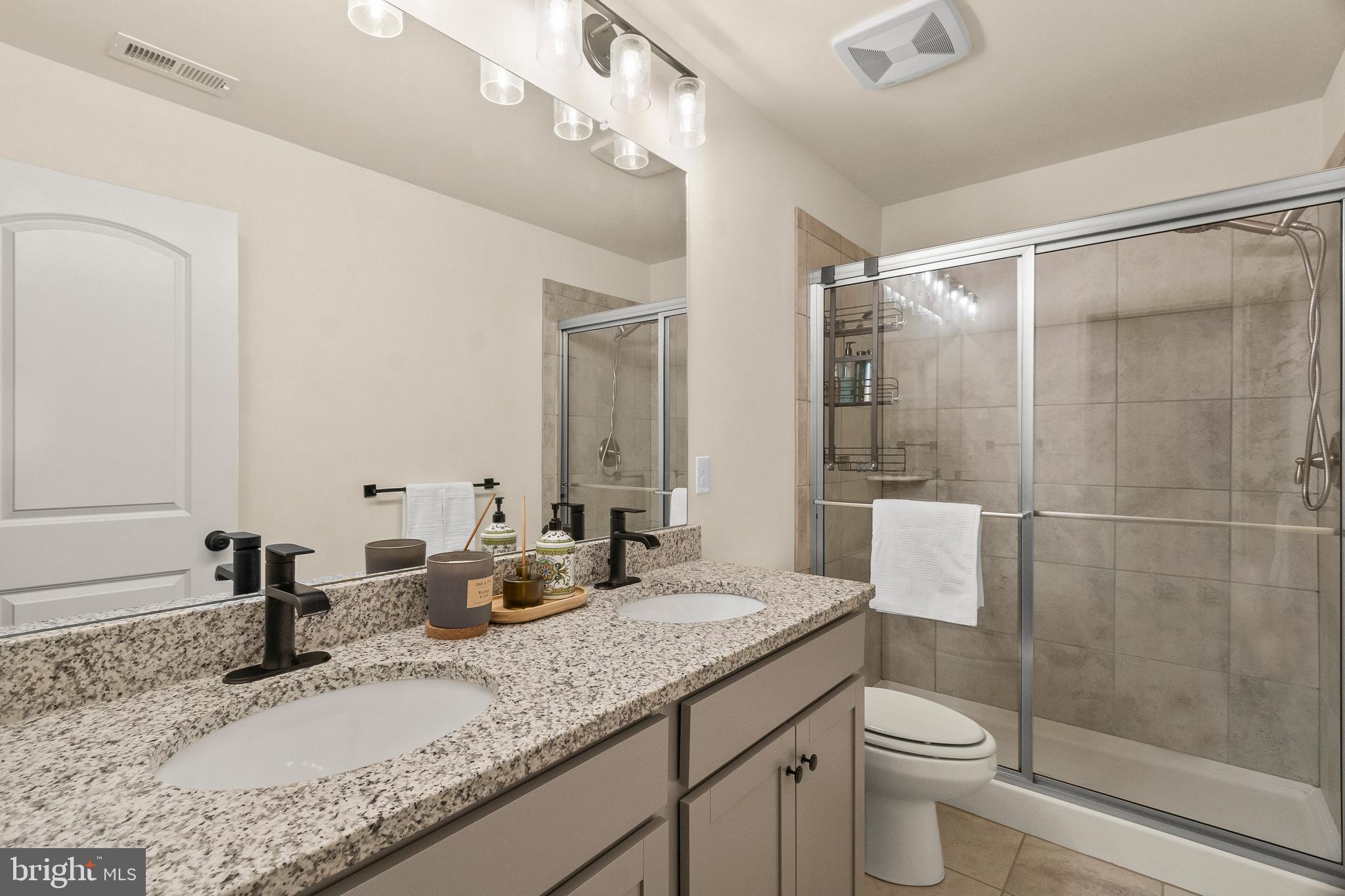 407 Sun Boulevard Bear, DE 19701 - Photo 52 of 69 a bathroom with a granite countertop sink a toilet and a shower
