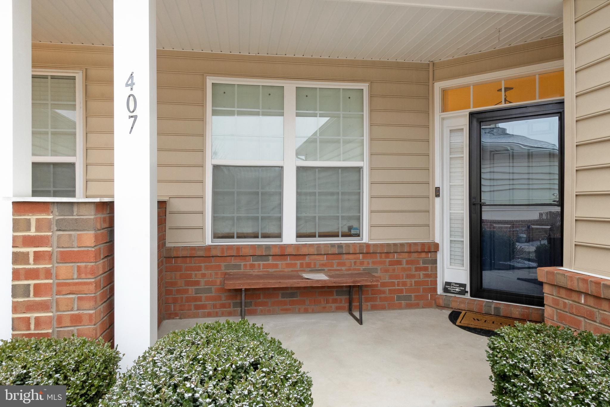 407 Sun Boulevard Bear, DE 19701 - Photo 7 of 69 front view of a brick house with a large window and a bench