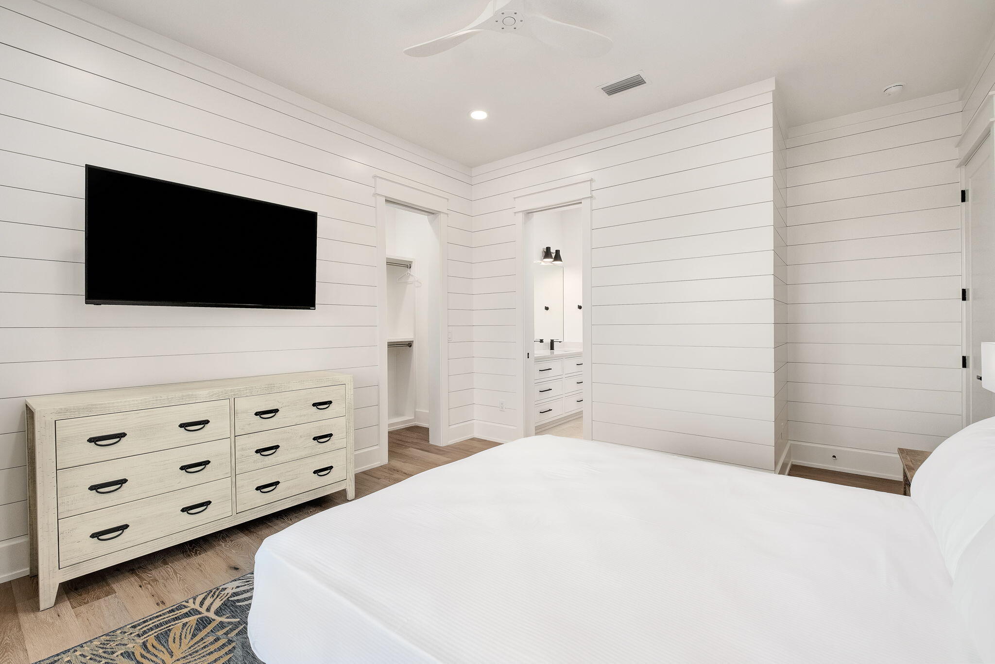 7570 East County Highway 30A Watersound, FL 32461 - Photo 36 of 64 a bedroom with a bed a flat screen tv and a mirror on the dresser