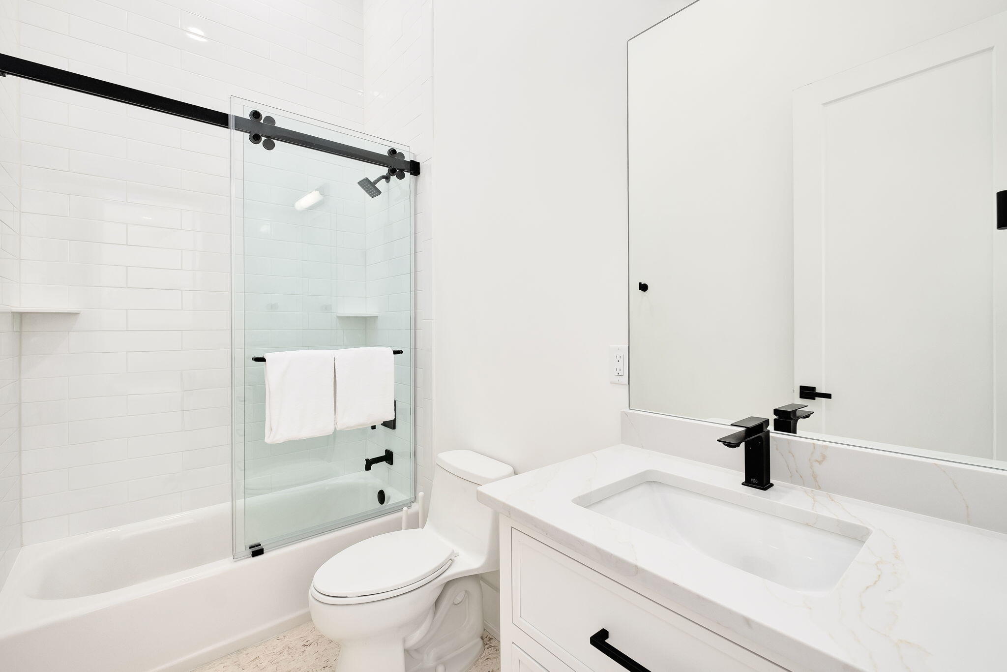 7570 East County Highway 30A Watersound, FL 32461 - Photo 55 of 64 a bathroom with a sink a toilet and a large mirror