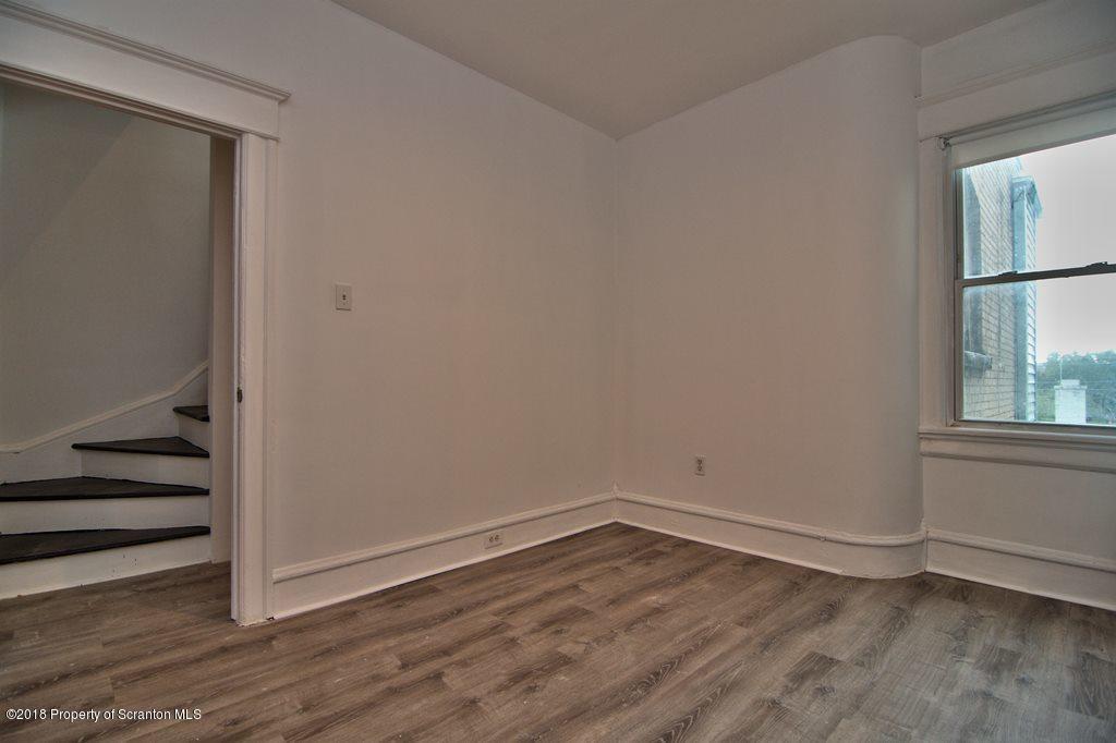 1324 Linden Street Scranton, PA 18510 - Photo 18 of 28 a view of an empty room with wooden floor and a window