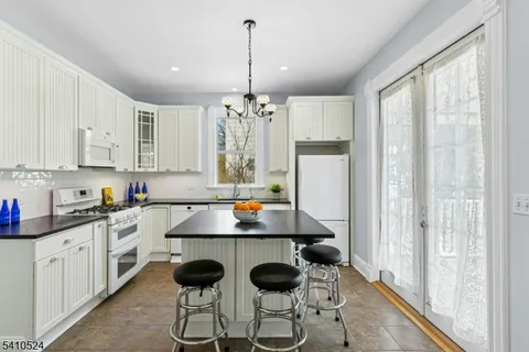 a kitchen with stainless steel appliances a stove a refrigerator and white cabinets