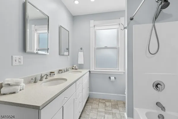 a bathroom with a granite countertop sink a shower and a mirror