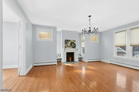 a view of a livingroom with wooden floor and a kitchen