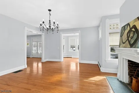 a view of a room with wooden floor and chandelier