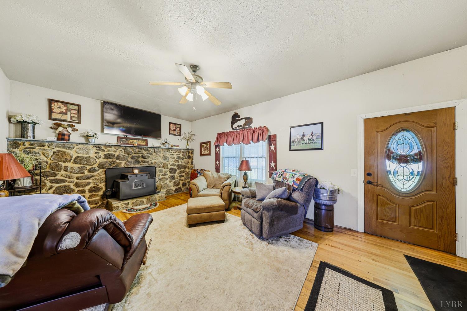 809 Plantation Road Amherst, VA 24521 - Photo 7 of 77 a living room with furniture a flat screen tv and a fireplace