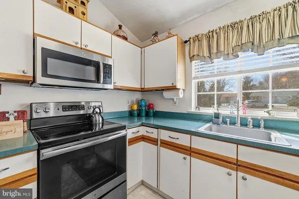 a kitchen with stainless steel appliances a stove sink and microwave