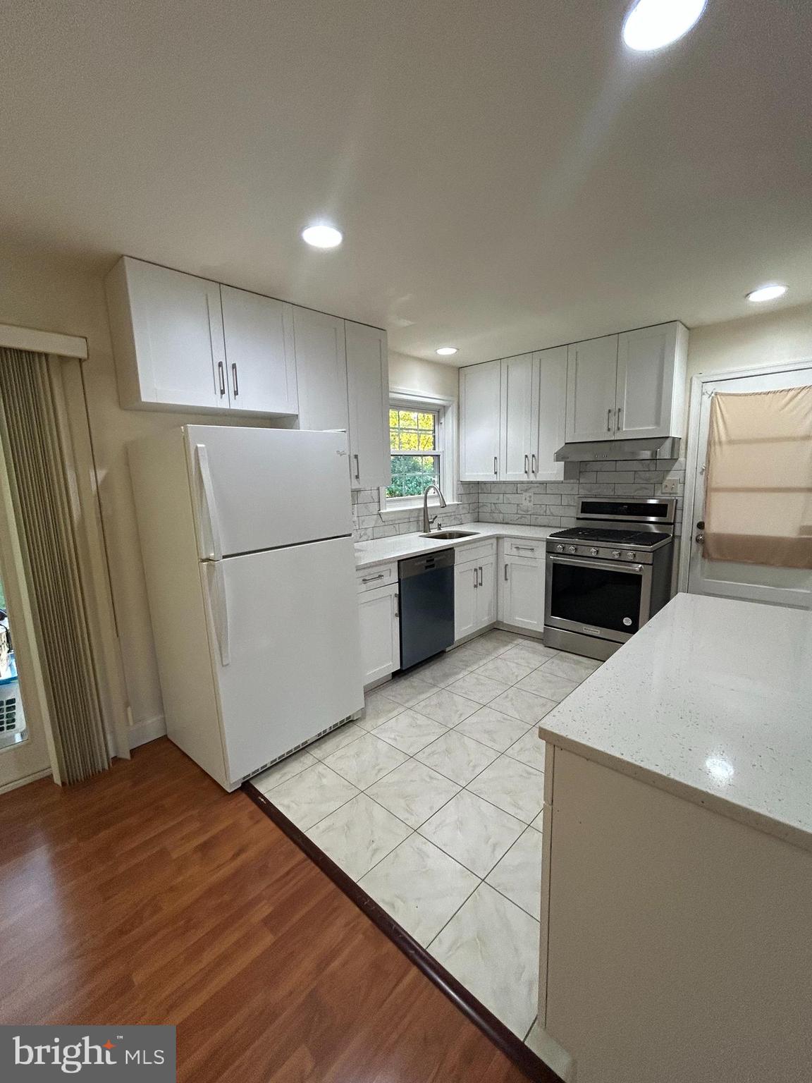 7511 Hamlet Street Springfield, VA 22151 - Photo 24 of 40 a kitchen with a refrigerator a stove top oven and wooden floor