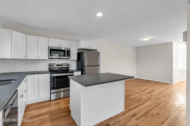 a kitchen with granite countertop a sink and steel appliances