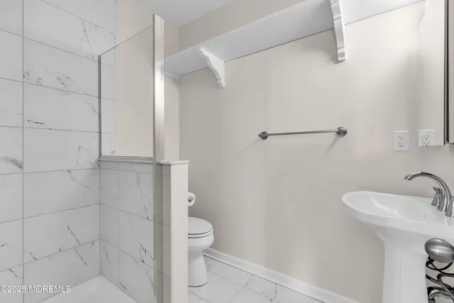 a bathroom with a toilet a sink and shower