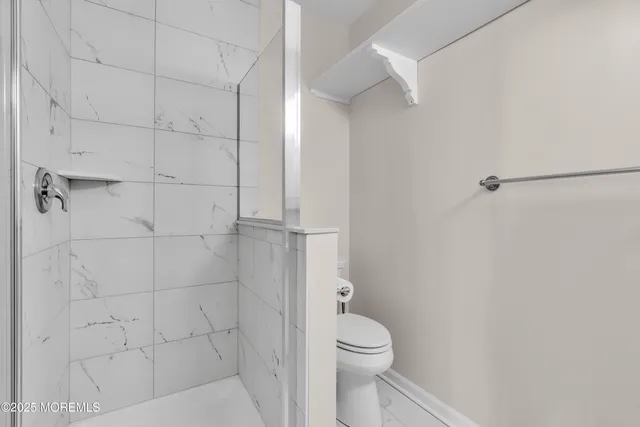 a bathroom with a toilet and a shower