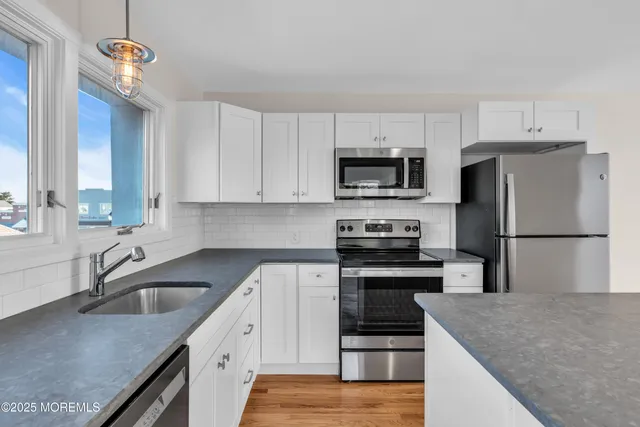 a kitchen with a sink a stove a microwave and refrigerator