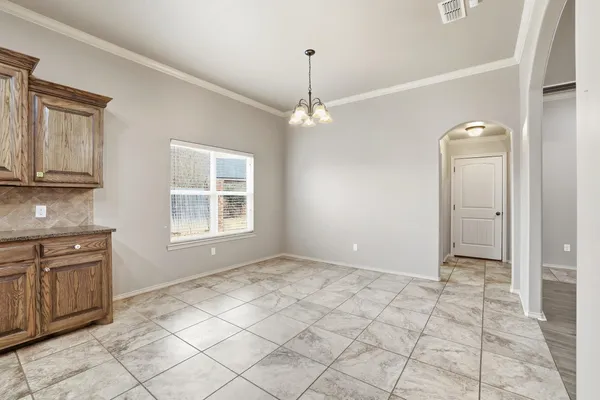 a view of an empty room with window and cabinet