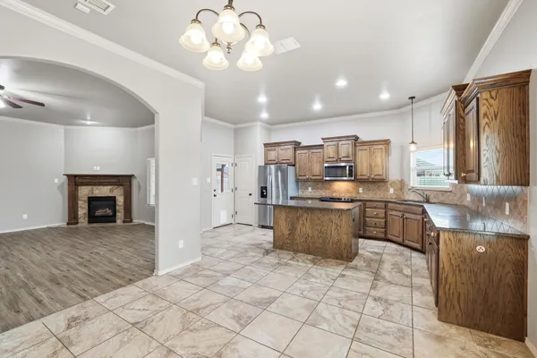a large kitchen with stainless steel appliances granite countertop a stove refrigerator a sink dishwasher with a dining table and chairs