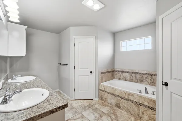 a bathroom with a granite countertop sink a mirror and a bathtub
