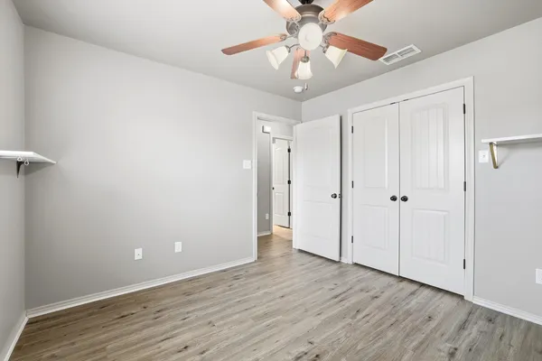 a view of an empty room with wooden floor