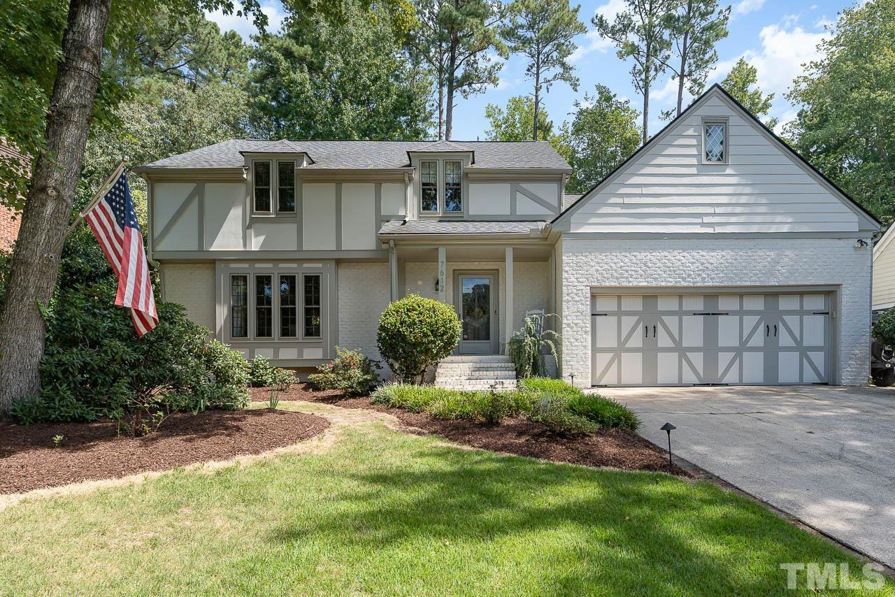 a front view of a house with a yard and potted plants