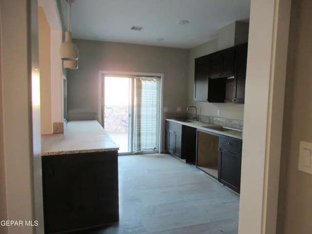a kitchen with stainless steel appliances granite countertop a sink and a refrigerator