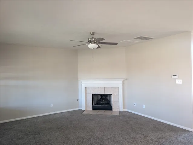 an empty room with fireplace and fan