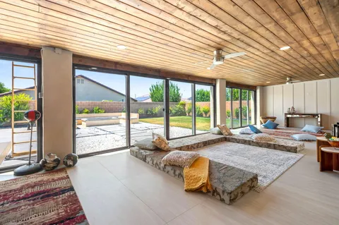 a bedroom with furniture and large windows