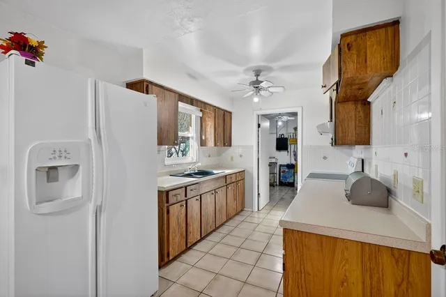 a kitchen with stainless steel appliances granite countertop a refrigerator and a stove top oven