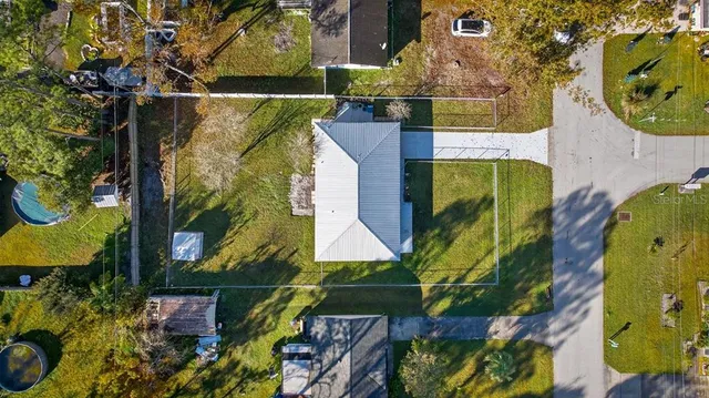 a view of a house with a yard and large tree