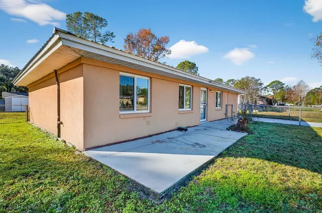a living room with furniture and a chandelier fan