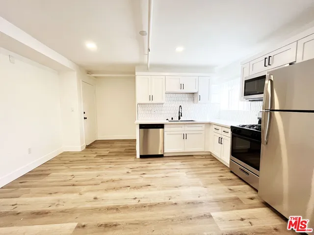 a kitchen with white cabinets and white appliances