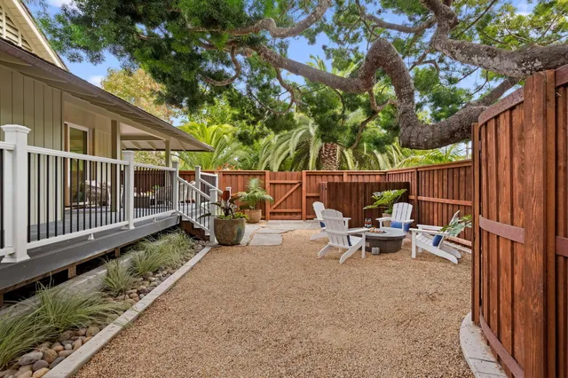 a view of a chair and tables in the back yard of the house