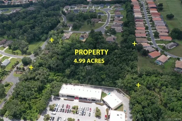 an aerial view of residential house with outdoor space and trees all around