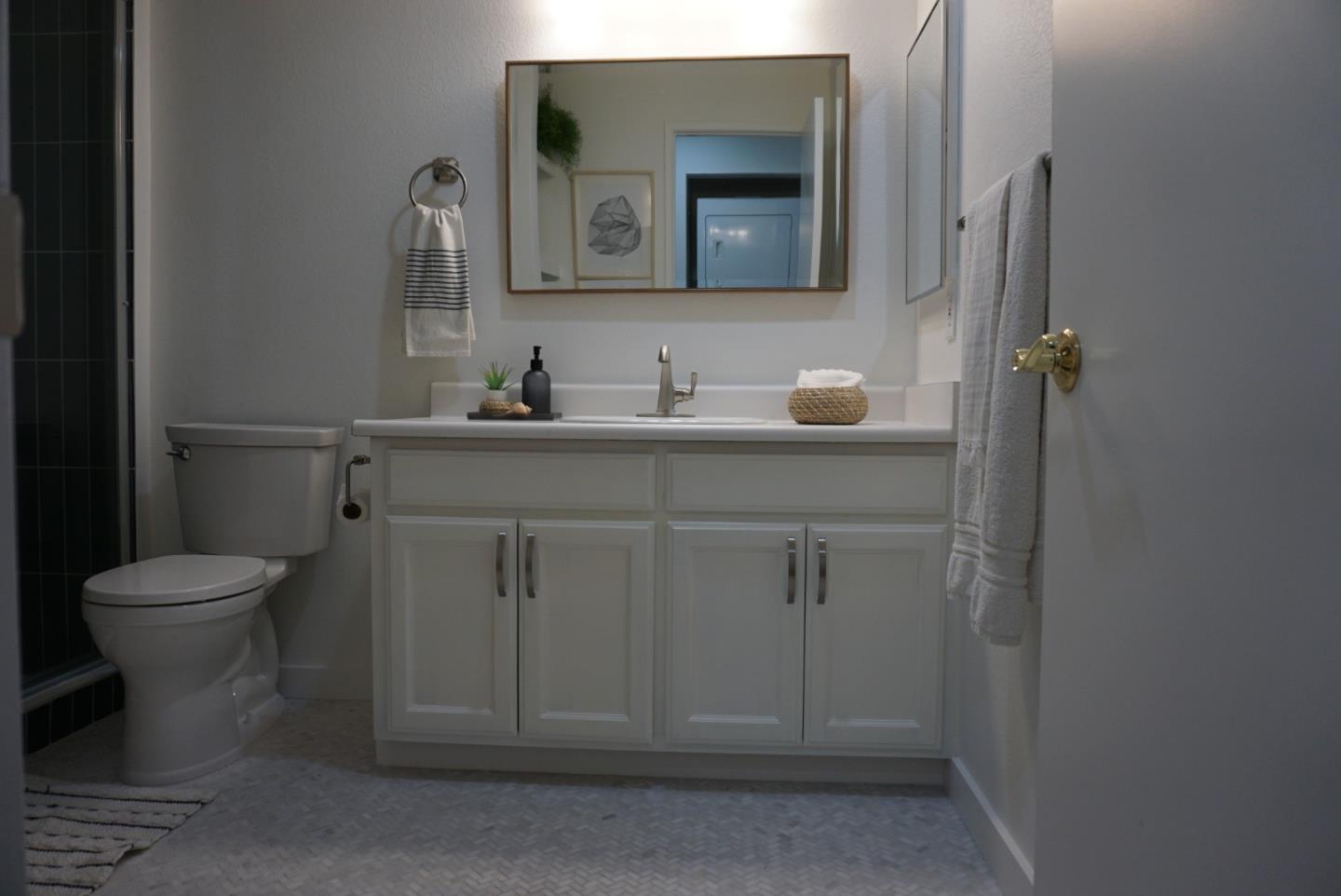 666 Encore Way San Jose, CA 95134 - Photo 28 of 41 a bathroom with a toilet a sink and mirror