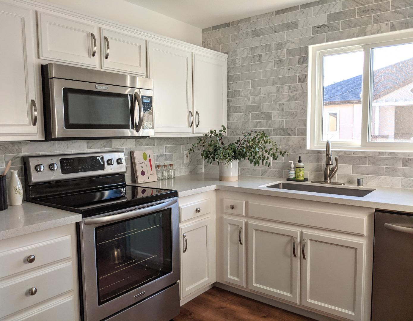 666 Encore Way San Jose, CA 95134 - Photo 10 of 41 a kitchen with white cabinets and stainless steel appliances