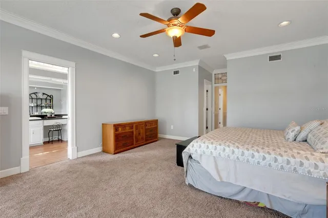 a spacious bedroom with a large bed and a chandelier