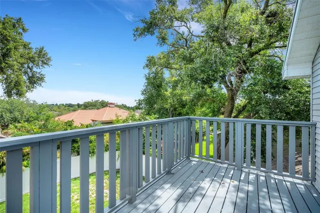 a front view of a house with a yard and large trees