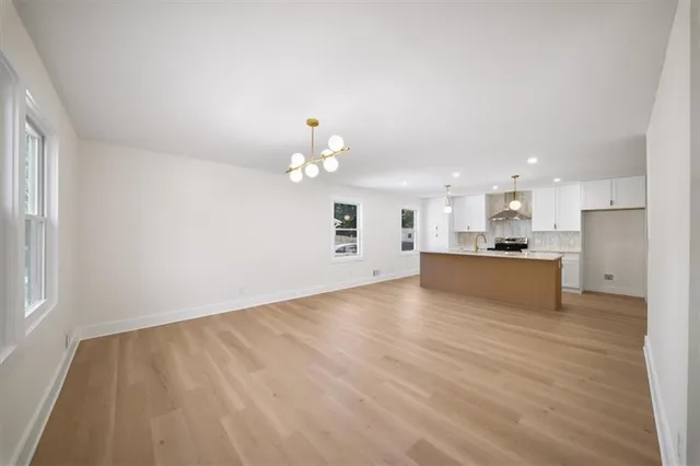 a view of a kitchen with kitchen island stainless steel appliances refrigerator sink and cabinets