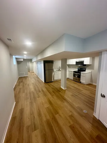 a view of empty room with wooden floor