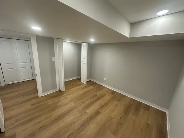 an empty room with wooden floor and entrance