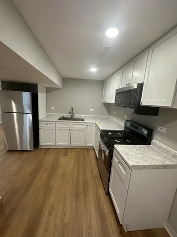 a kitchen with granite countertop a sink and steel appliances