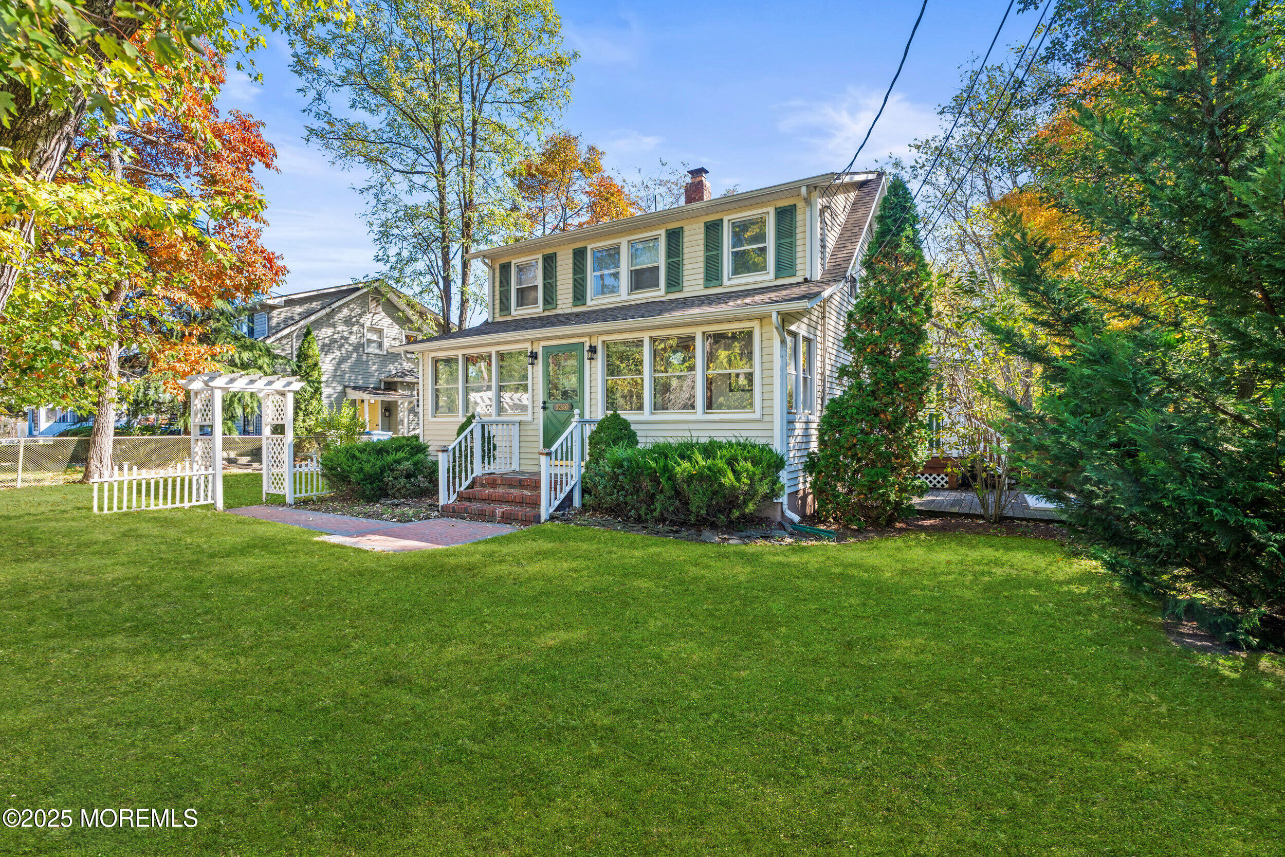a front view of a house with a yard and trees