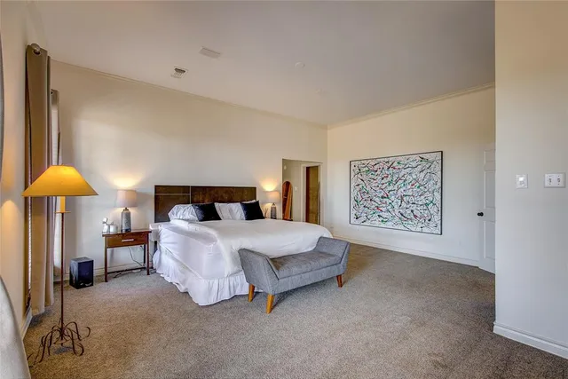 a spacious bedroom with a bed and lamp