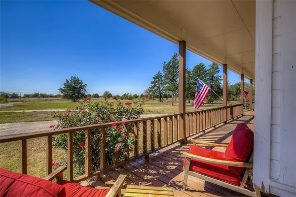 a view of a balcony with wooden floor and outdoor seating
