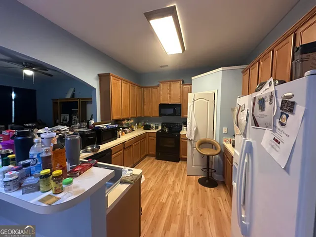 a view of a kitchen with fridge and workspace
