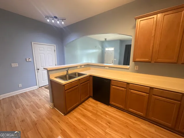 a kitchen with wooden floor and a refrigerator