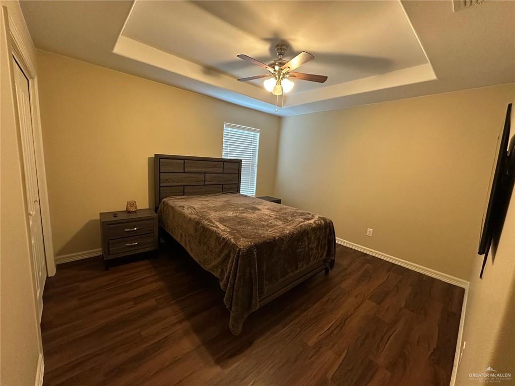 4608 Robin Avenue McAllen, TX 78504 - Photo 11 of 12 Bedroom featuring wood-finish flooring, a tray ceiling, and a ceiling fan with integrated lighting