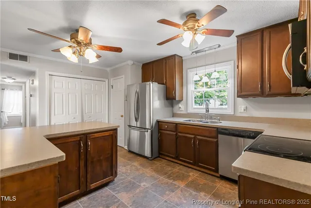 a kitchen with stainless steel appliances granite countertop a sink a stove and refrigerator