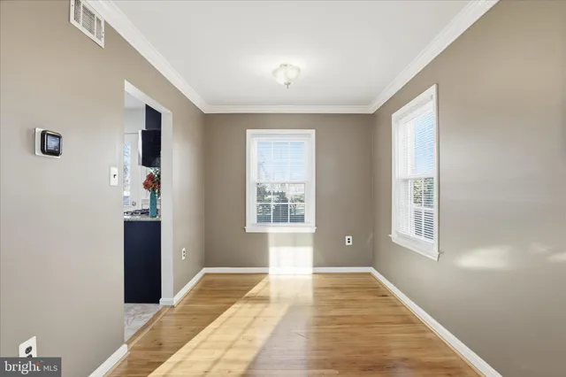 a bedroom with wooden floor and windows